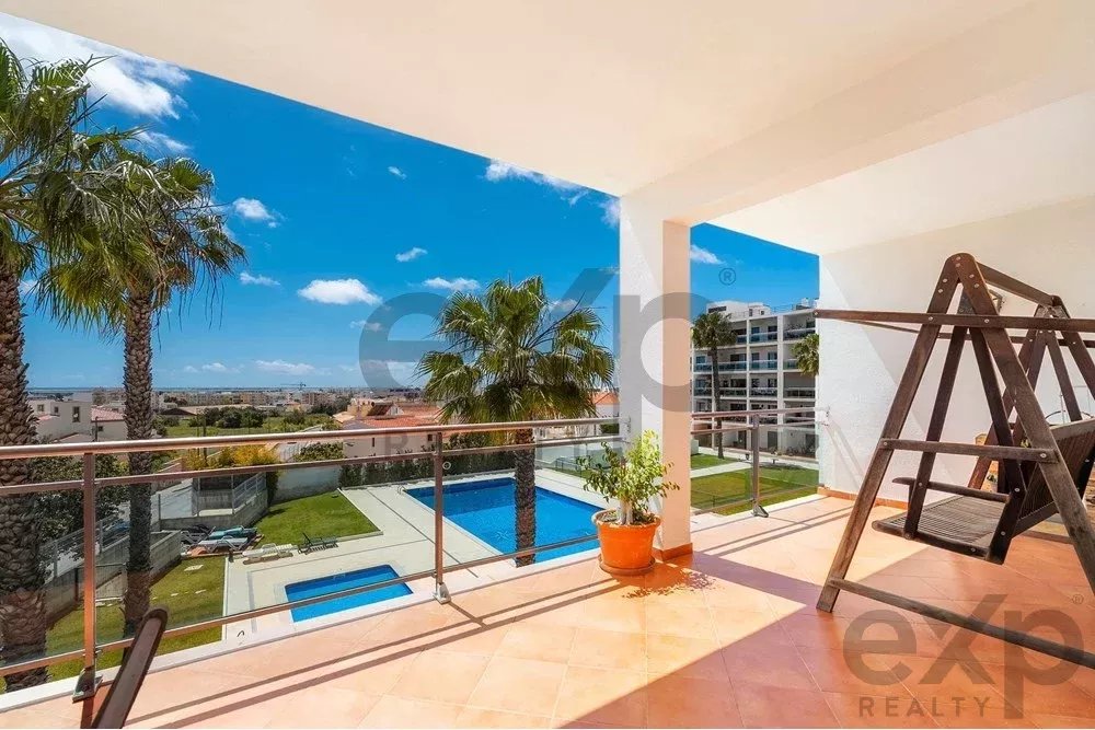 Espaçoso apartamento de 4 quartos em Olhão, localizado num condomínio de luxo com duas piscinas partilhadas e ginásio. Interiores amplos e terraço.