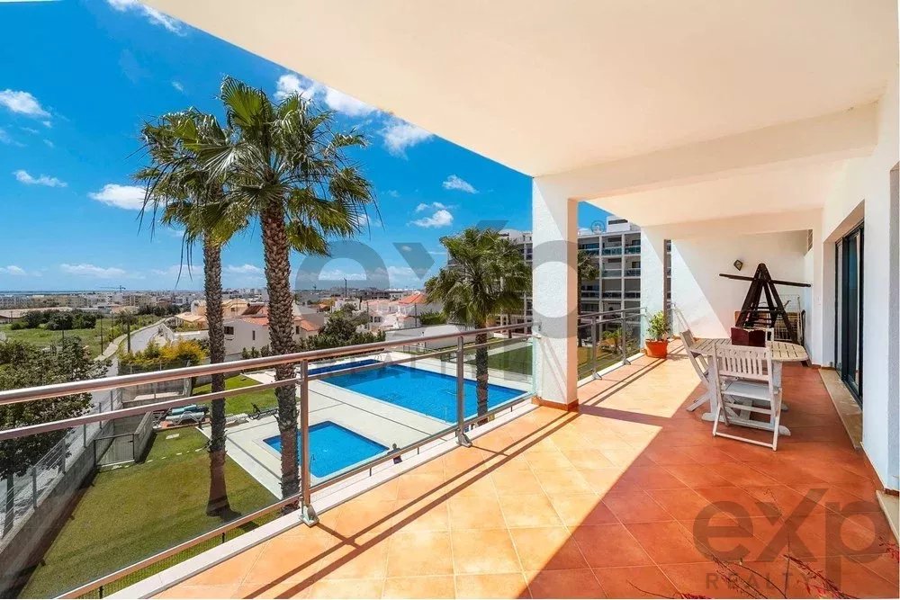 Espaçoso apartamento de 4 quartos em Olhão, localizado num condomínio de luxo com duas piscinas partilhadas e ginásio. Interiores amplos e terraço.